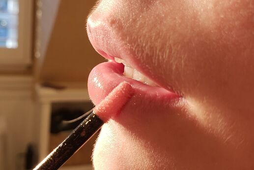 woman applying lip gloss