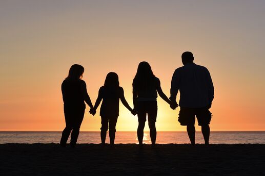 sillouette of family on the beach